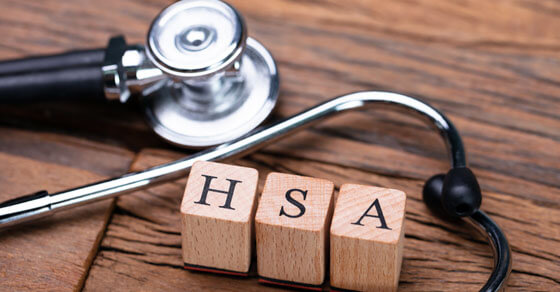 block letters spelling out "HSA" on a table next to stethoscope