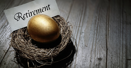 a golden egg in a nest sitting on a table with the sign "retirement" next to the egg.