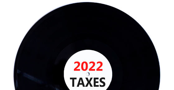 Business concept of planning 2022 taxes happy new year. Concept words Taxes 2022 on black vinyl disc. Beautiful white background, copy space. Business, 2022 taxes happy new year concept.