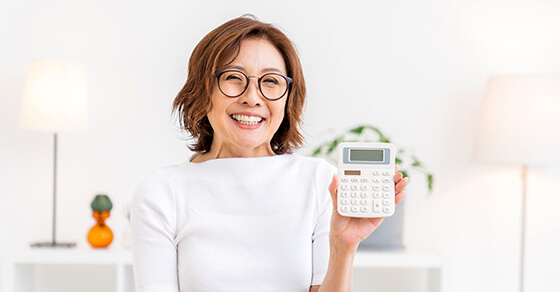 photo of smiling individual holding up a calculator