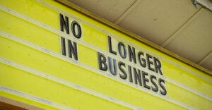 sign with "no longer in business" written on it