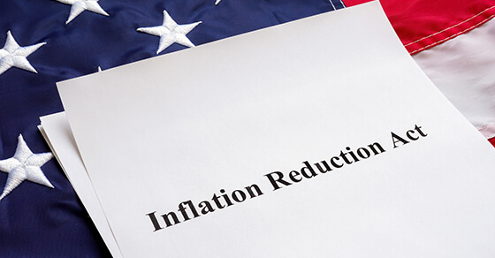 Papers with Inflation Reduction Act and US flag.