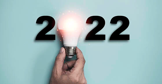 Hand holding Light bulb with 2022 year for happy new year idea and creative thinking concept.
