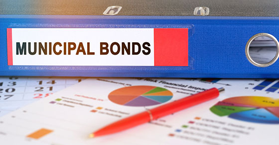 binder labeled "municipal bonds" on a table with paperwork and graphs.