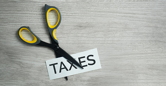 Scissors cut the word "taxes". 