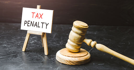 little sign with "tax penalty" next to a gavel.