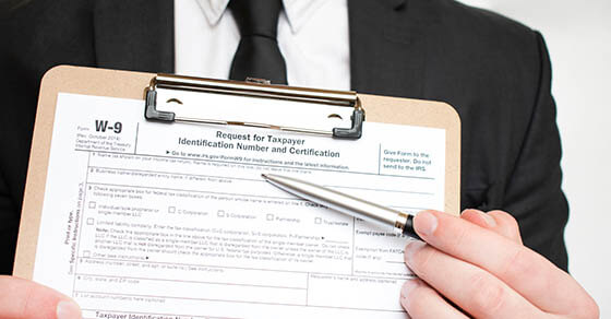 Man holding US tax form W-9. Tax form law document irs business concept