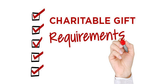 a hand writing on a white board "charitable gift requirements" with check boxes