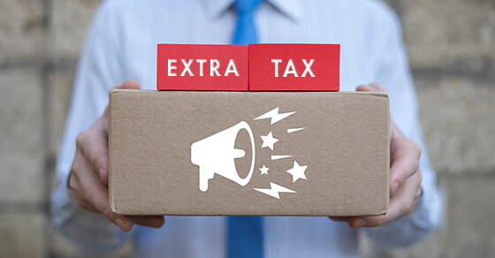 a person holding a box with the image of a blow horn and the words "extra tax" written above.