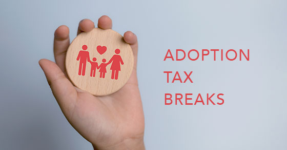 a hand holding a coaster with the image of a family on it. And the words "Adoption Tax Breaks" next to it.